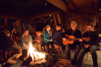 Campers are playing music in the room with the open fireplace